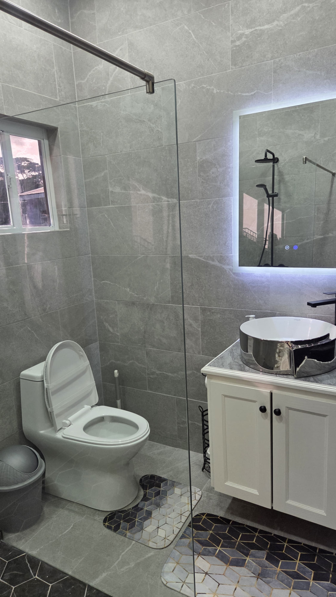 En-suite bathroom with floating vanity, vessel sink and backlit LED mirror